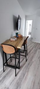 a wooden table with a chair and a television at Azure Loft 2 in Mosteiros