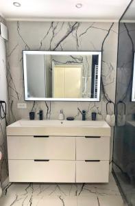 a bathroom with a white sink and a mirror at Studio 36mt2 a 5 min a pied boulevard de Belgique MC in Beausoleil