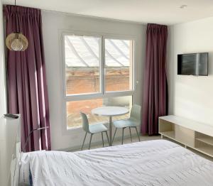 a bedroom with a bed and a table and two chairs at Studio proche gare et sanctuaire in Lourdes