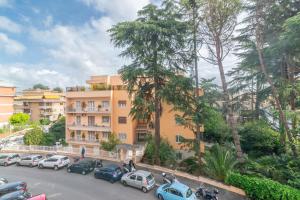 un parcheggio con auto parcheggiate di fronte a un edificio di Casa Eva - Roma a Roma