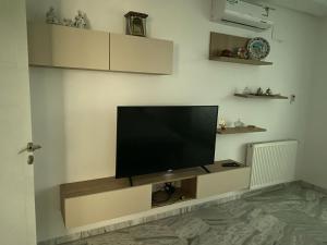 a flat screen tv on a wall in a living room at Diamant ikbel in Harqalah