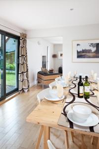 a dining room with a table with wine bottles on it at Bright, contemporary house & large private garden in Strathpeffer