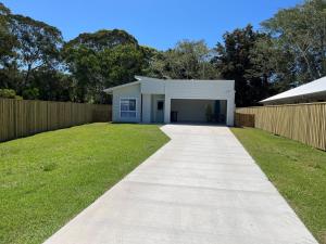 a driveway leading to a white garage at 6 Yeri Drive - Rainbow Shores. Aircon. Pets Welcome. Walk to beach in Rainbow Beach