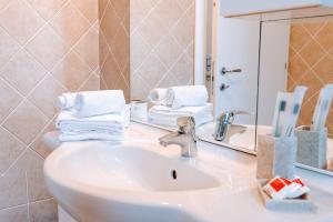 un lavandino in bagno con asciugamani e specchio di La Petite Vue ad Aosta