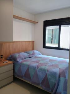 a bedroom with a bed and a dresser and a window at Recanto Aguapés in Governador Celso Ramos