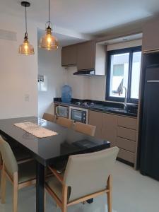 a kitchen with a dining room table and chairs at Recanto Aguapés in Governador Celso Ramos