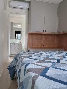 a bedroom with a blue and white bed and a sink at Recanto Aguapés in Governador Celso Ramos +18 photos