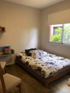 ein Schlafzimmer mit einem Bett in einem Zimmer mit einem Fenster in der Unterkunft Excelente casa en Barrio Privado Los Arces in Pilar + 12 Fotos