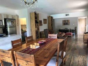 ein Wohnzimmer mit einem Holztisch und einem Esszimmer in der Unterkunft Excelente casa en Barrio Privado Los Arces in Pilar