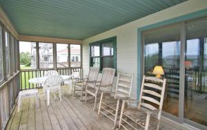 a porch with a white table and chairs and windows at Belvedere in Edisto Island
