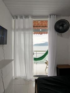ein Schlafzimmer mit einem Fenster mit Blick auf das Meer in der Unterkunft Casa no Mar de Junqueira in Mangaratiba