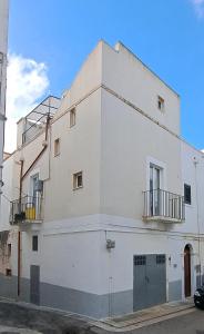 a white building with two balconies on a street at Casa Margherita in Noci