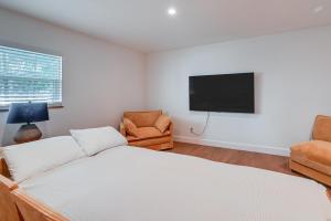 a bedroom with a bed and a tv and a chair at Naples Duplex Home with Private Pool and Lanai! in Naples