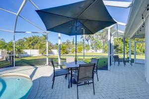 a patio with a table and chairs and an umbrella at Naples Duplex Home with Private Pool and Lanai! in Naples
