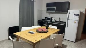 a kitchen with a wooden table with chairs and a refrigerator at Alquiler Centro SAN RAFAEL in San Rafael