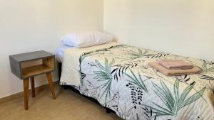 a bedroom with a bed with a nightstand next to it at Alquiler Centro SAN RAFAEL in San Rafael