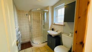 a bathroom with a shower and a toilet and a sink at Traditional Highland Cottage Near Loch Ness in Drumnadrochit +43 photos