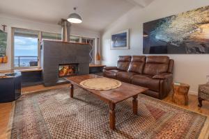 un salon avec un canapé et une cheminée dans l'établissement 56 Becker Road, à Forster