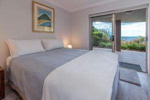 une chambre avec un lit blanc et une grande fenêtre dans l'établissement 56 Becker Road, à Forster 15 autres photos