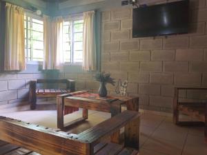 a living room with two tables and a flat screen tv at CABAÑA DORADA in Villa Ciudad de América