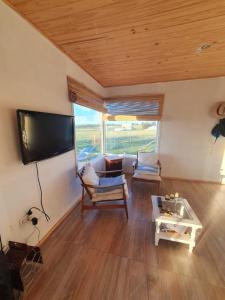 a living room with a flat screen tv and a table at Casa en Chapa in La Estafeta