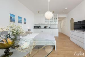 una cocina blanca con mesa de cristal en una habitación en Apartment in Pobierowo near Baltic Beach, en Pobierowo