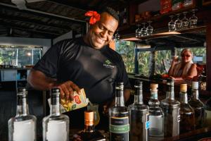 a man standing behind a counter with bottles of wine at Likuri Island Resort Fiji in Natadola