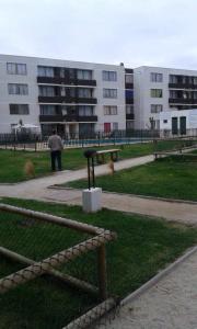 a man standing in a park in front of a building at Departamento Peñuelas in La Serena