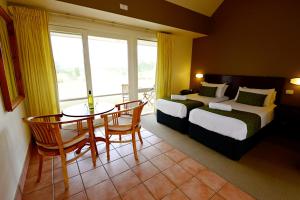 Habitación de hotel con 2 camas, mesa y sillas en Rothbury Escape, en Rothbury