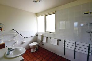 uma casa de banho com um WC, um lavatório e uma janela em Rothbury Escape em Rothbury