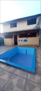 a large blue swimming pool in front of a building at Casa de praia Maçarico in Salinópolis