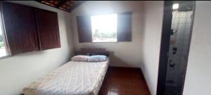 a small room with a bed and a window at Casa de praia Maçarico in Salinópolis