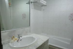 a white bathroom with a sink and a tub at Oriental Smile Hotel in Bangkok +113 photos