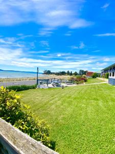a yard with a view of the ocean at Swansea Motor Inn Tasmania in Swansea