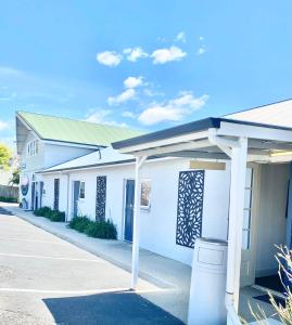 a white building with a green roof at Swansea Motor Inn Tasmania in Swansea +37 photos