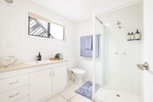 un bagno bianco con doccia e WC di Sunrise Court a Bargara