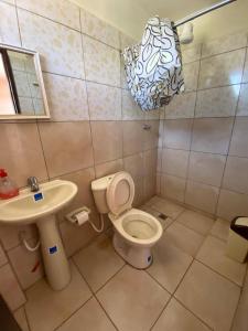 ein Badezimmer mit Toilette und Waschbecken in der Unterkunft Hostal La Familia in Torotoro