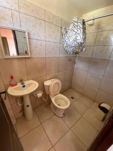 ein Badezimmer mit Toilette und Waschbecken in der Unterkunft Hostal La Familia in Torotoro