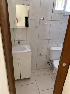 a small bathroom with a toilet and a sink at Casa para veraneio in Rio Grande