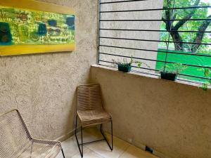 a chair sitting next to a window with potted plants at Allende Apart St in Villa Allende