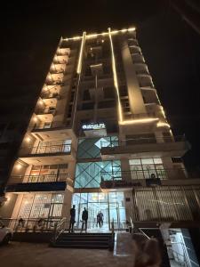 two people standing in front of a building at night at Adwa Mega City Luxury Apartment in Addis Ababa