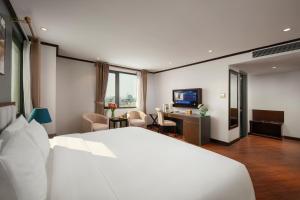 a hotel room with a white bed and a desk at MAY DE VILLE Corner Hotel in Hanoi