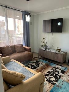 a living room with a couch and a table at Depto Montserrath en Condominio 3D 1B Parking Excelente Conectividad, Atención Empresas-Facturas in Chillán