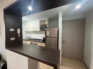 a kitchen with a counter top and a refrigerator at Depto Montserrath en Condominio 3D 1B Parking Excelente Conectividad, Atención Empresas-Facturas in Chillán +5 photos