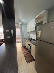a kitchen with a refrigerator and a stove at Depto Montserrath en Condominio 3D 1B Parking Excelente Conectividad, Atención Empresas-Facturas in Chillán