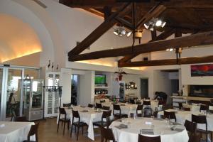 une salle à manger avec des tables et des chaises blanches dans l'établissement Albergo Umbria, à Otricoli