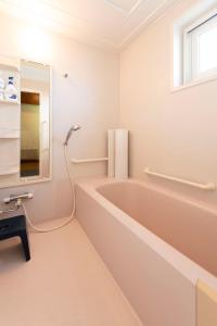 a bathroom with a bath tub and a sink at villa the rise hakodate in Hakodate