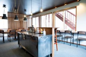 a room with a bar and some chairs and windows at ロッヂモントゼー in Yuzawa