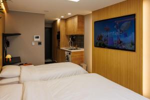 a hotel room with two beds and a kitchen at WECO STAY Insadong in Seoul