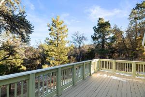 a wooden deck with a fence and trees at The Beary Cozy Cabin, Huge Snow Play Area! in Sugarloaf +11 photos